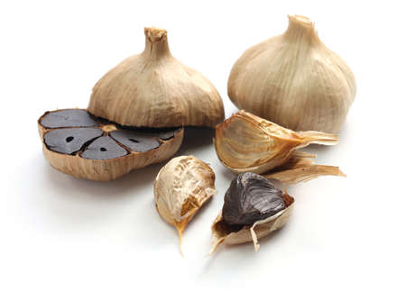 black garlic bulbs and cloves on white backgroundの写真素材