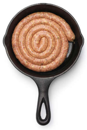 raw cumberland sausage, spiral pork sausage on skillet isolated on white backgroundの写真素材
