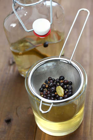 making homemade gin, straining infused liqueur