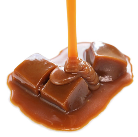 pouring homemade caramel sauce on caramel candiesの写真素材