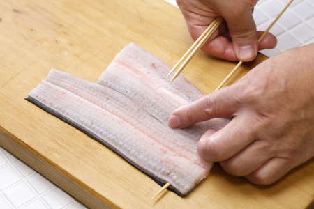 Preparing Japanese Unagi(eel) dishes; Putting the eel on skewers.の写真素材