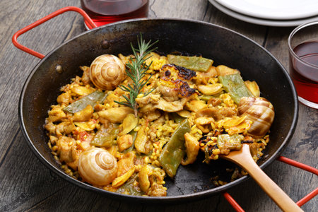 traditional Valencian paella in Spain; rabbit, chicken, garrofon beans, snails, Moroccan green beans, saffron, and bomba rice.の写真素材