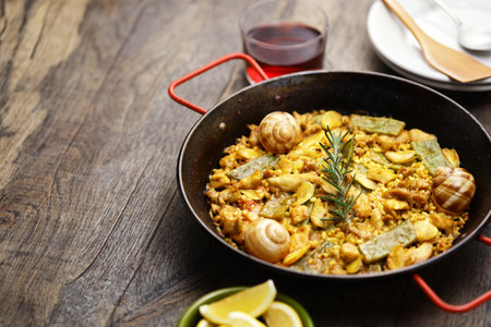Spanish Valencian traditional paella; rabbit, chicken, garrofon beans, snails, Moroccan green beans, saffron, and bomba rice.の写真素材