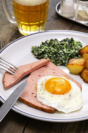 LeberkÃ¤se with spinach, potatoes and fried egg, Austria and southern German dishの写真素材