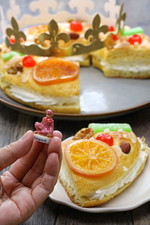 RoscÃ³n de reyes, Spanish Kingâs cake.
getting one figurine of the three wise men Biblical Magi from a king cake.の写真素材
