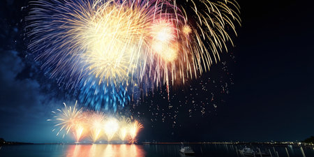 Incredibly beautiful fireworks over water against the sky at night. Generative AI.の素材