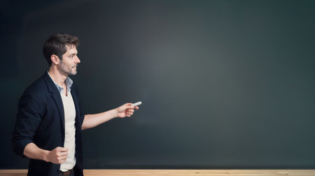 passionate male teacher trying to write something on the blackboard with chalk. Copyspace. Generative AIの素材