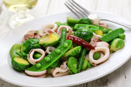 Spring salad with peas, beans, brussels sprouts, and calamari.の写真素材