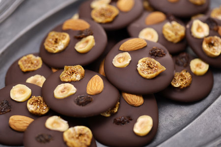 homemade chocolate mendiants with traditional toppings; almonds, raisins, hazelnuts, fig.   French Christmas sweets.の写真素材