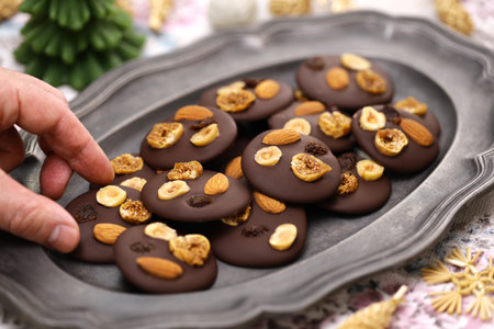 homemade chocolate mendiants with traditional toppings; almonds, raisins, hazelnuts, fig.   French Christmas sweets.の写真素材