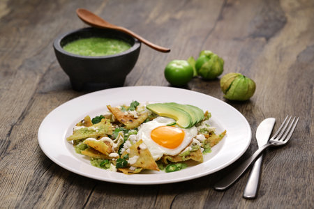 chilaquiles, Mexican breakfast. Totopos topped with salsa verde, fried egg, and avocado.の写真素材