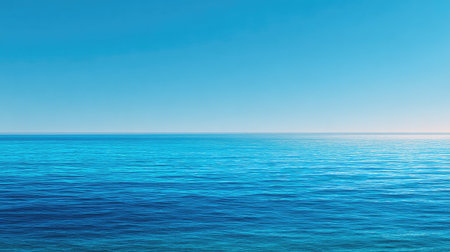 A stunning view of a vast blue ocean under a clear sky, showcasing gentle waves creating a serene and tranquil atmosphere perfect for relaxation and escapism.の素材