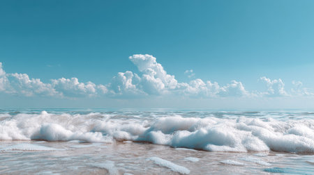Experience the soothing beauty of ocean waves gently crashing on a sandy beach under a bright sky filled with fluffy clouds. A perfect serene escape.の素材