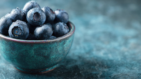 A close-up of luscious fresh blueberries in a rustic bowl, set against a textured backdrop. Perfect for promoting healthy eating and vibrant recipes.の素材