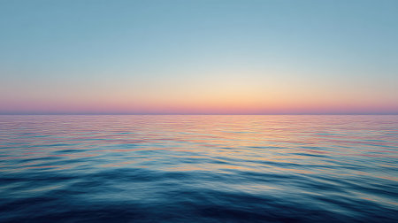 A peaceful view of the ocean at sunset, showcasing a stunning gradient sky filled with soft pink and blue hues reflected in calm water, evoking tranquility.の素材