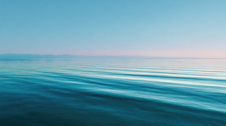 This stunning seascape captures the serene beauty of gentle ocean waves under a clear blue sky at dusk. The tranquil scene invites relaxation and reflection.の素材