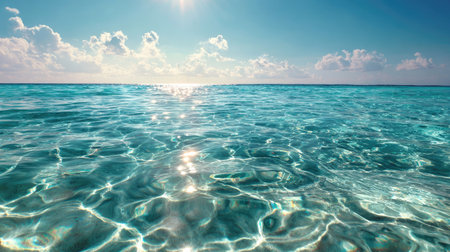 A breathtaking view of sunlit waves gently rippling across the clear ocean water, showcasing the beauty of nature under a vast blue sky. Perfect for travel themes.の素材