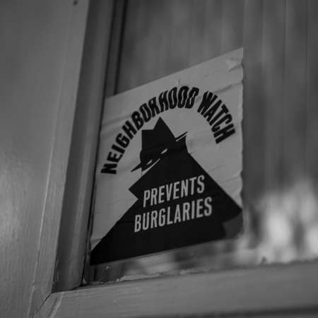 A neighborhood watch sticker on a doorの写真素材