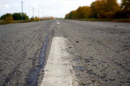 an asphalt road among rural autumn landscapesの写真素材