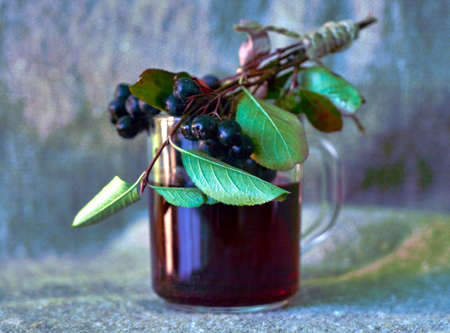 a glass mug with rowan compote and rowan berries are located nearbyの写真素材