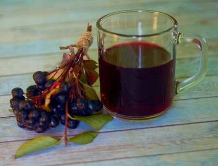 a glass mug with rowan compote and rowan berries are located nearbyの写真素材