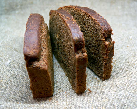 black bread with raisins lies on a surface made of burlapの写真素材