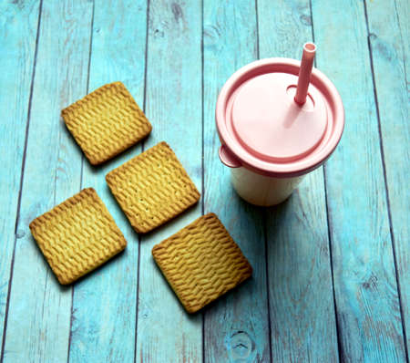 cookies and a glass with a straw for soft drinksの写真素材