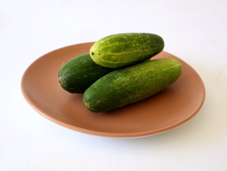 three cucumbers piled on a plateの写真素材