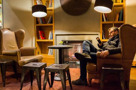 A man is using his phone at hotelのeditorial素材