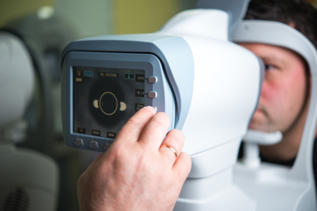 The ophthalmologist conducts the research with the help of various equipment, a contactless tonometer, for the diagnosis of eye diseaseの写真素材