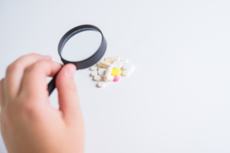 Tablets and medicines under the magnifying glass, the study of the composition of tabletsの写真素材