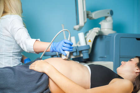 Ultrasound machine doctor"s hand usg investigation USCG, pregnant womanの写真素材