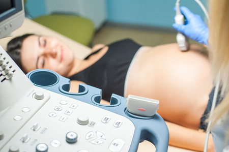 Ultrasound machine doctor"s hand usg investigation USCG, pregnant womanの写真素材