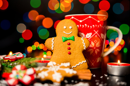 Christmas card - gingerbread man gingerbread, christmas decor, snow, candles, cup with cocoa, tea or coffee and Christmas lightの写真素材