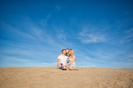 Family playing on the beach, fly, run, laugh at the blue sky backgroundの写真素材