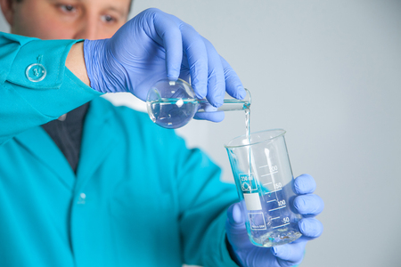 scientist or laboratory technician working with dispenser, a centrifuge, test tubes and other laboratory instrumentsの写真素材
