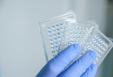 scientist or laboratory technician working with dispenser, a centrifuge, test tubes and other laboratory instrumentsの写真素材