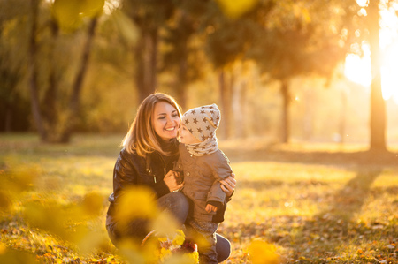 Mom and son with a small child are walking in a autumn forest or park, mother's dayの写真素材