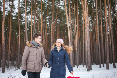 couple in the forest in winter, walk, kiss, hug and hold hands heartの写真素材