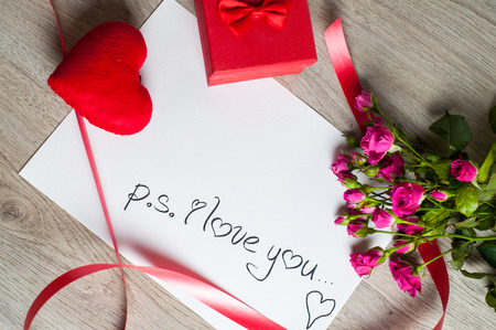 Composition consist of roses, gift boxes and heart near the white sheet with the inscription "I love you" on Valentine's Day or any other holidayの写真素材
