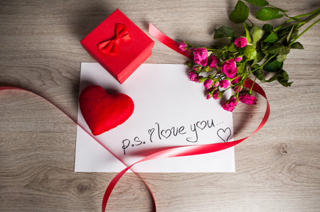 Composition consist of roses, gift boxes and heart near the white sheet with the inscription "I love you" on Valentine's Day or any other holidayの写真素材