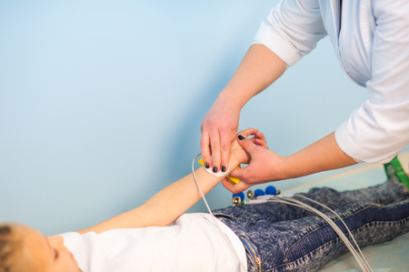 Electrocardiogram, cardiac cardiograph and conduct research in pediatrics, a girl doing an electrocardiogram