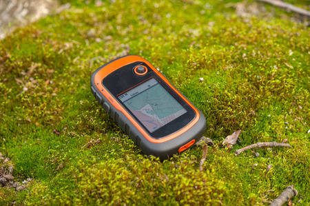 GPS device in the forest on a moss, outdoor, hiking, trekking
