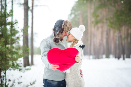 couple in the forest in winter, walk, kiss, hug and hold hands heartの写真素材