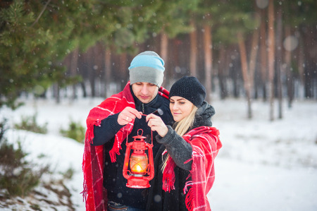Couple hugging under a blanket, and hold vintage style red lampの写真素材
