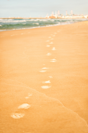 Footprints on the warm yellow sand near sea or oceanの写真素材