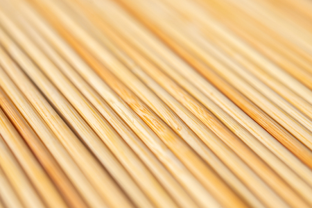 background of parallel round wooden sticks closeupの写真素材