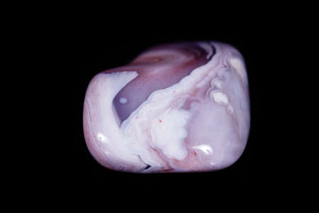 Macro mineral stone Agate pink Persian on a black background close up