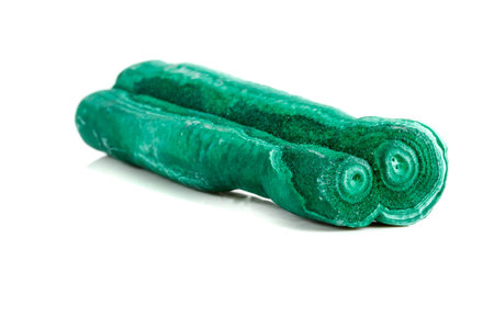 Macro mineral stone malachite stalactite on white background close up