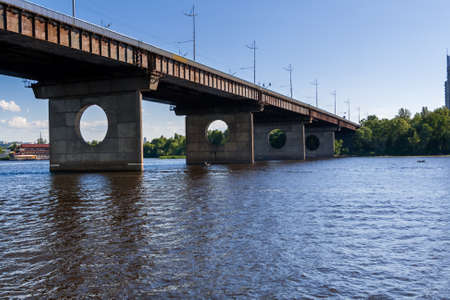 Bridge on a river against a blue sky and clouds